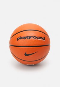 Pallone da basket arancione con superficie texturizzata, caratterizzato da dettagli neri e testo "playground OUTDOOR GAME BALL", insieme al logo Swoosh della Nike.