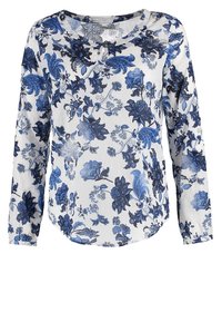 Chemise blanche à manches longues avec motif floral bleu et noir et petit détail œillet à bouton près du col.
