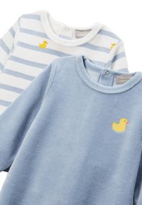 Deux bodies pour bébé, l'un bleu clair uni et l'autre blanc avec des rayures bleues, tous deux ornés d'un petit motif de canard en caoutchouc jaune.