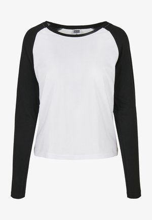 Top alb cu mâneci lungi și mâneci raglan negre. Material din bumbac moale, decolteu rotund și croială lejeră. Eticheta spune "Urban Classics."