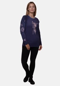Navy long-sleeve shirt with gray neckline, featuring pink graphic design of a character and celestial symbols on sleeves; cotton blend fabric.