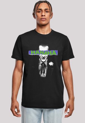 Black cotton t-shirt featuring a graphic of a smiling character with a flower, overlaid with the text "HAHAHA" in blue and green.