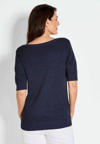 Dunkelblauer gestrickter Pullover mit kurzen Ärmeln und weitem Ausschnitt; verfügt über einen gerippten Saum und strukturierten Stoff.