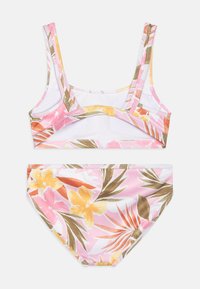 Ensemble de maillot de bain deux pièces avec un motif floral rose sur fond blanc. Le haut a des bretelles larges, et le bas est taille mi-haute.
