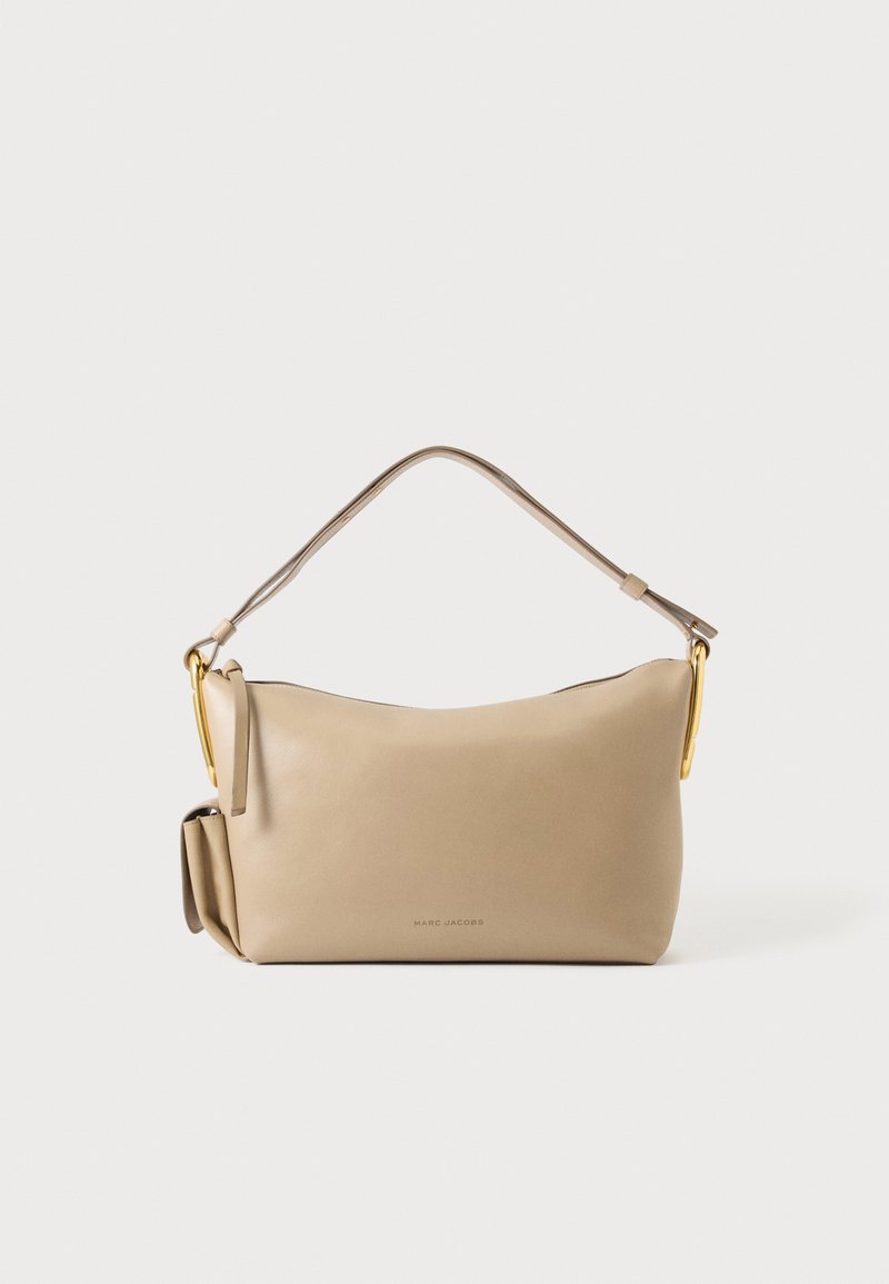 Sac à main rectangulaire en cuir beige avec une seule bandoulière, des ferrures dorées et une petite poche latérale, marqué Marc Jacobs au centre devant.