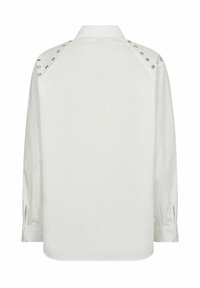 Blusa bianca con maniche lunghe, colletto e borchie argentate sulle cuciture delle spalle. Tessuto liscio, orlo arrotondato e polsini con bottoni.