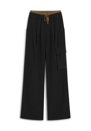 Schwarze weit geschnittene Hose mit elastischem Bund und braunem Kordelzug, mit seitlichen Taschen und einer cargo Tasche am linken Bein.