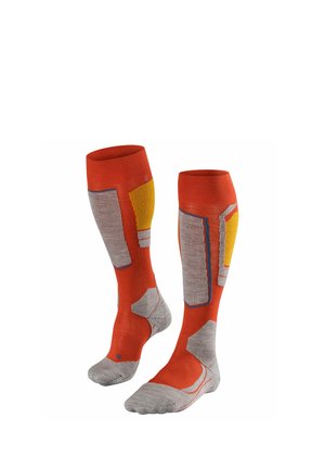 Par de calcetines naranjas hasta la rodilla con secciones acolchadas grises y amarillas diseñadas para soporte y protección.