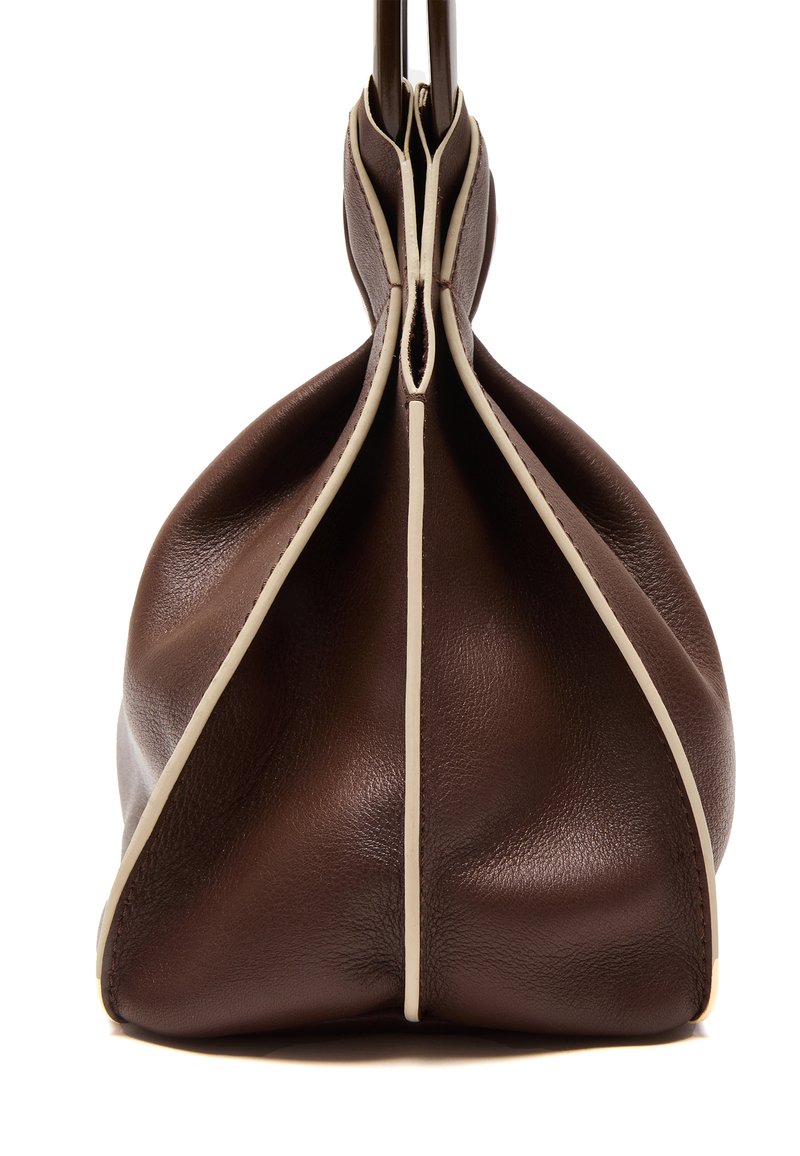 Braune Lederhandtasche mit einem weichen, gerafften Design. Kontrastierende cremefarbene Nähte betonen die Kanten und Nähte. Glatte Textur mit abgerundeter Form.