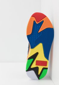 Multicolored athletic shoe sole featuring prominent blue, yellow, green, orange, and red sections with textured patterns and logo elements.