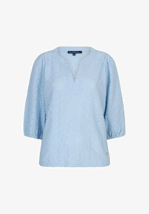 Lichtblauwe blouse met oogjeskantpatroon, driekwart pofmouwen en een lichte V-hals.
