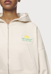 Pegador FLORA LOGO CROPPED JACKET - Sweater met rits - washed coast sand