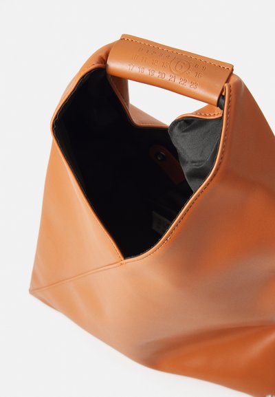 Brun läderhandväska med ett vikt handtag som visar präglade siffror; väskan är öppen och avslöjar ett svart tyginrede.