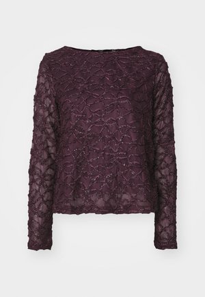 Haut transparent à manches longues de couleur violet profond, avec un motif texturé et des accents scintillants. Ourlet droit et décolleté large.