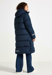 Cappotto imbottito blu navy con cappuccio, caratterizzato da cuciture orizzontali, dettagli riflettenti sulle maniche e design fino al ginocchio.