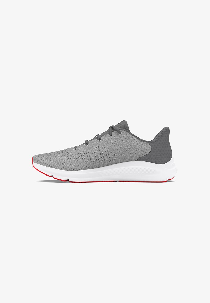 Gray athletic shoe with a textured upper, featuring ventilation holes, a white midsole, and red outsole accents. Laced design and curved shape.