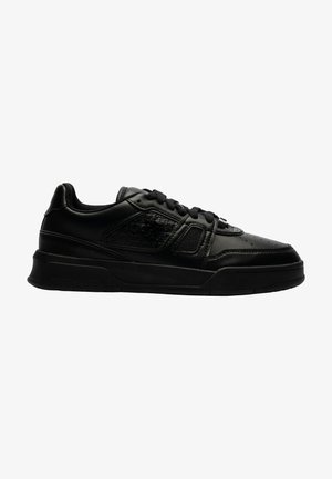Baskets basses noires à lacets, avec panneaux latéraux texturés, col rembourré et semelle en caoutchouc épaisse, vues de côté gauche.