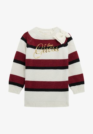 Gestreepte trui in crème, bordeaux en zwart. Heeft gouden "Ik hou van Guess" tekst en een strikdetail op de schouder. Gebreide textuur.