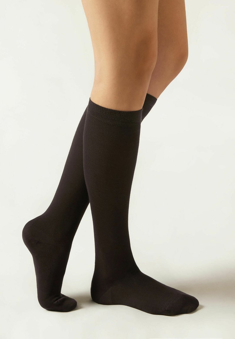 Calcetines negros hasta la rodilla, fabricados con una tela suave y de textura ligera, que cuentan con un puño acanalado y un diseño de punta sin costuras.