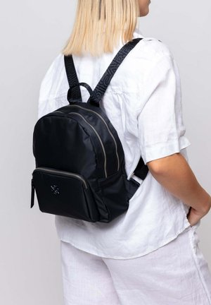 Black nylon backpack with a rounded shape, dual zippers, and a front pocket. Features webbed straps with textured accents.
