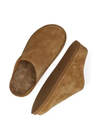 Pantofole slip-on in suede color tan con punta arrotondata, texture morbida e tacco basso a zeppa. L'interno presenta dettagli del logo in rilievo.