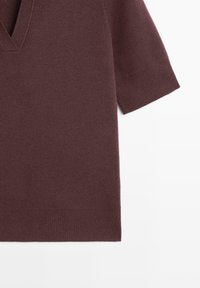 Bordeaux kortærmet sweater med V-udskæring lavet af blødt stof. Har ribbede kanter og en afslappet pasform.