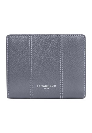 Cartera de cuero texturizado gris con costuras verticales y "LE TANNEUR 1898" grabado en blanco en el centro frontal.