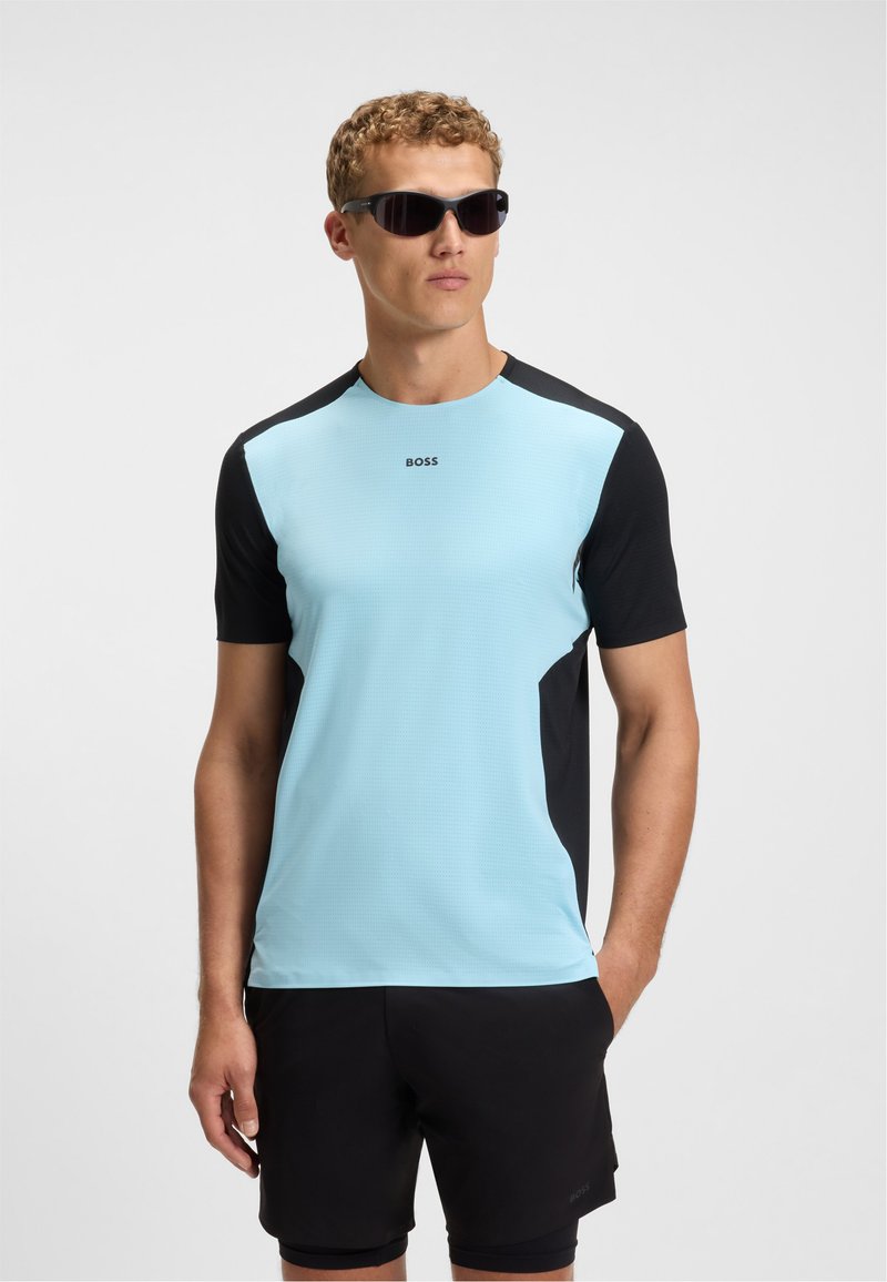 Light blue athletic shirt with black accents, short sleeves, textured fabric, and "BOSS" logo on the chest, paired with black shorts.