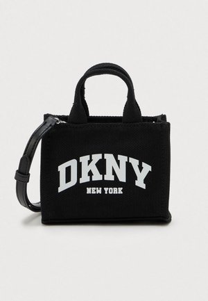 Fekete DKNY vászontáska rövid fülekkel, levehető fekete pánttal, és a "DKNY New York" felirattal fehér színben az elején.