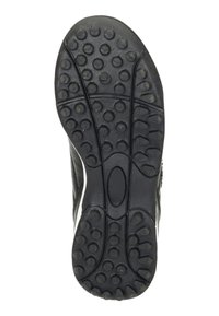 Semelle de chaussure en caoutchouc noir avec des motifs de grip circulaires, une surface texturée et une section centrale lisse ; forme contournée pour une meilleure adhérence.