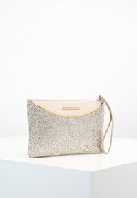 Gul glittrig clutchväska med en slät beige ovandel och en guldfärgad hårdvarudetalj. Har en avtagbar handledsrem och en böjd design.