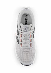 Zapatilla deportiva gris claro con una superficie texturizada, acentos negros, detalles rojos en los cordones y una suela acolchada. Logo visible en el interior.