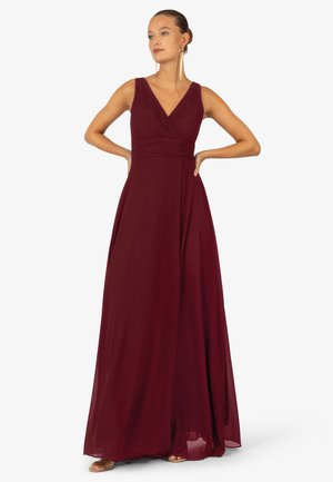 Bordeaux maxi-jurk met een diepe V-hals, geplooide corsage en zwierige rok. Gemaakt van lichte stof voor een soepele textuur.