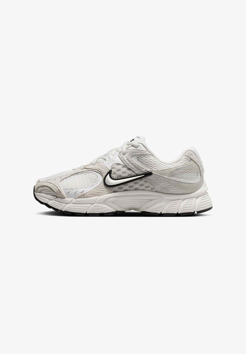 Λευκό και ανοιχτό γκρι παπούτσι τρεξίματος Nike με μαύρο λογότυπο Swoosh, επάνω μέρος από δίχτυ και σουέτ, και υφασμένη σόλα σε πλευρικό προφίλ.