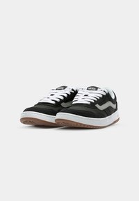 Svarta och grå sneakers med vita snören och en sula av gummigummi. Har en vadderad krage och Vans-logotypen på tungan.