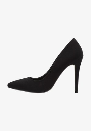 Black high heel shoe made of soft suede, featuring a pointed toe and a slender stiletto heel. The design is smooth with no visible accents.