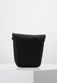 Svart texturerad läderpung med en strukturerad form och en vikt topp. Minimalistisk design, inga synliga detaljer eller accenter.