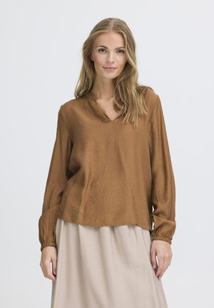 Braune Bluse mit langen Ärmeln, V-Ausschnitt und gerafften Manschetten, aus leichtem Stoff. Der Saum ist hinten etwas länger.