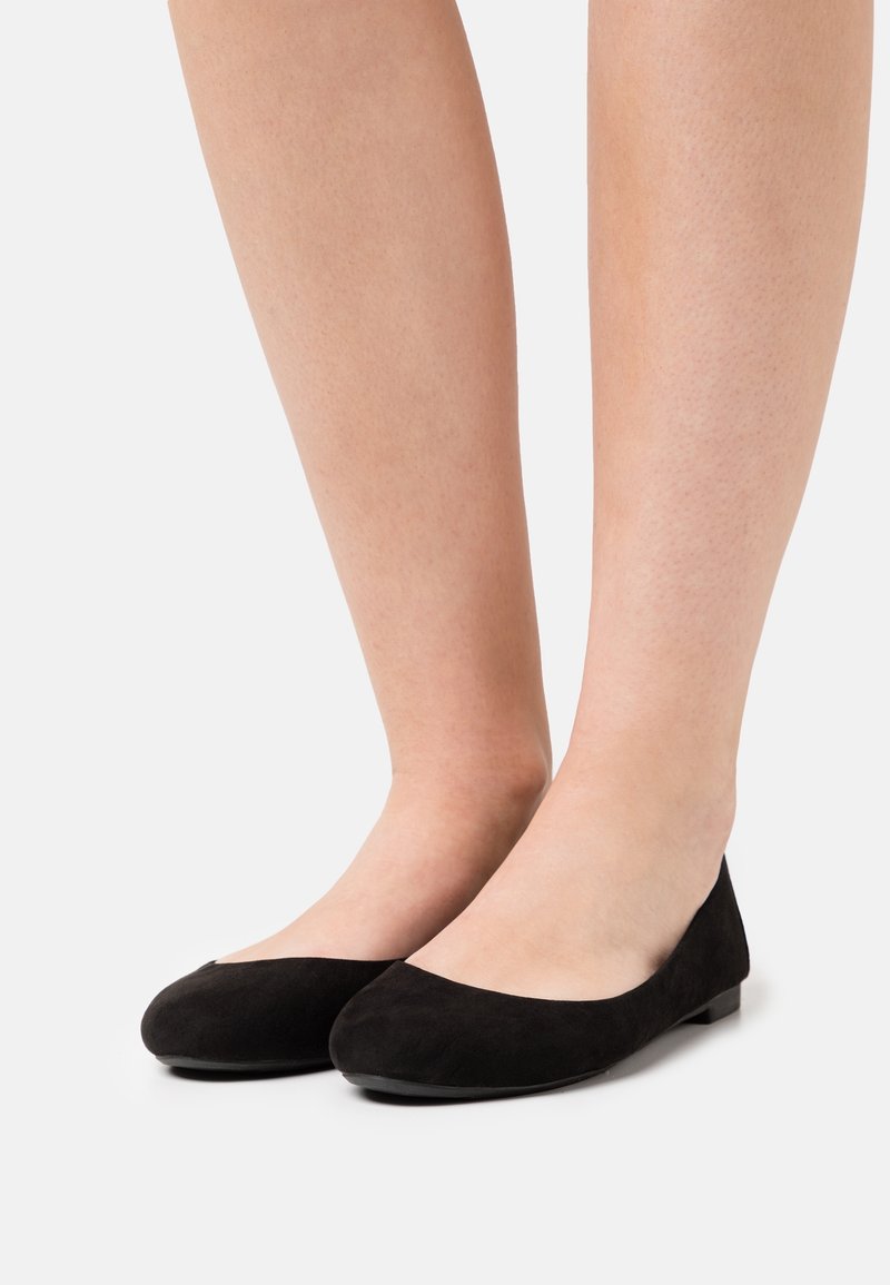 Bailarinas de ante negro con puntera redondeada y suela plana. Presentan una textura suave y un diseño minimalista, adecuadas para un uso casual.