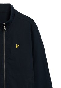 Giacca zip a navy in misto cotone con colletto alto, tasche laterali e logo giallo ricamato sul petto. Tessuto liscio con cuciture minime.
