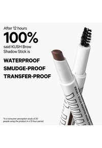 Two white KUSH Brow Shadow Sticks, one with angled brown tip and one with twisted spoolie brush, with text claiming 100% waterproof, smudge-proof, transfer-proof.