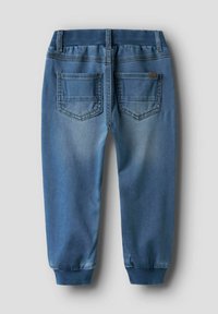 Denim joggerji v srednje modri barvi, z rebrastim pasom in zategnjenimi gležnji. Vključuje dve zadnji žepni z blagim bledenjem.