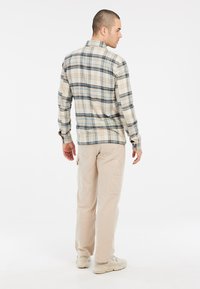 Beige geruite flanellen overhemd voor heren met blauwe en zwarte lijnen, lange mouwen, knopenmanchetten en een ontspannen pasvorm, gecombineerd met beige cargobroeken.
