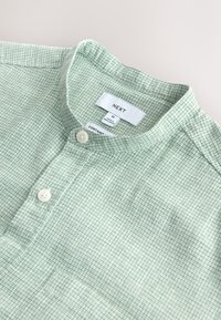 Chemise à carreaux vert clair et blanc avec col mandarin et deux boutons blancs, taille moyenne, marque NEXT.
