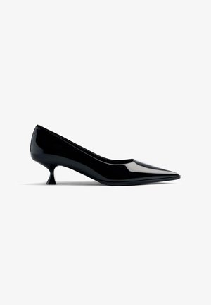 Zapato de tacón alto de charol negro con punta afilada y un diseño de tacón curvado, corto y único. Superficie lisa con un acabado brillante.