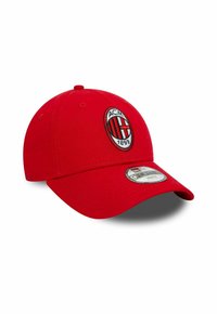 Rote Baseballmütze mit dem Logo des Fußballclubs AC Milan und einem Aufkleber auf dem gebogenen Schirm, auf weißem Hintergrund isoliert.