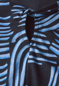 Svart tyg med blå och vita vågiga ränder, med en nyckelhålsöppning och en knuten detalj vid halsringningen. Slät textur.