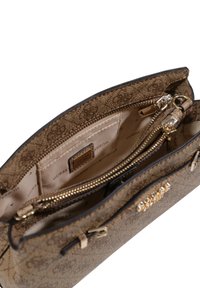 Bolso de mano de color marrón con un diseño estampado y textura suave, que cuenta con dos compartimentos con cremallera, herrajes dorados y una etiqueta de logo en el interior.