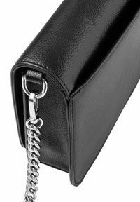 Czarna skórzana torebka o gładkiej teksturze, prostokątnym kształcie i srebrnym łańcuszku. Posiada zaokrąglone krawędzie i podkreślające elegancję akcenty metalowe.