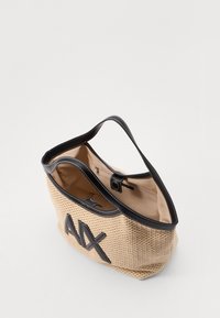 Woven beige tote bag with black faux leather accents, featuring large "AX" lettering and a spacious interior with a zippered pocket.